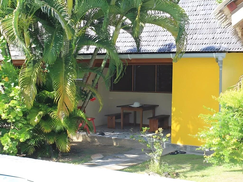Bungalow jaune de la pension Ariitere avec terrasse dans le jardin