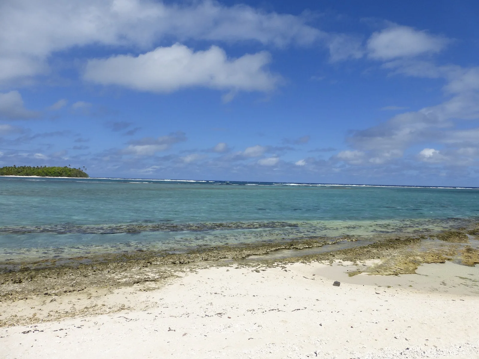 Une plage de sable clair au bord du lagon de Huahine.