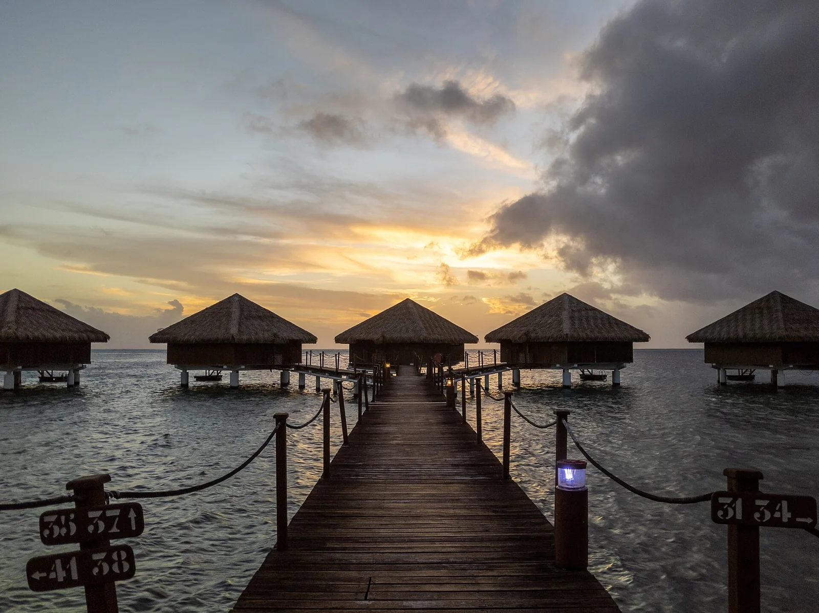 Le soleil se couche derrière des bungalows de Huahine.