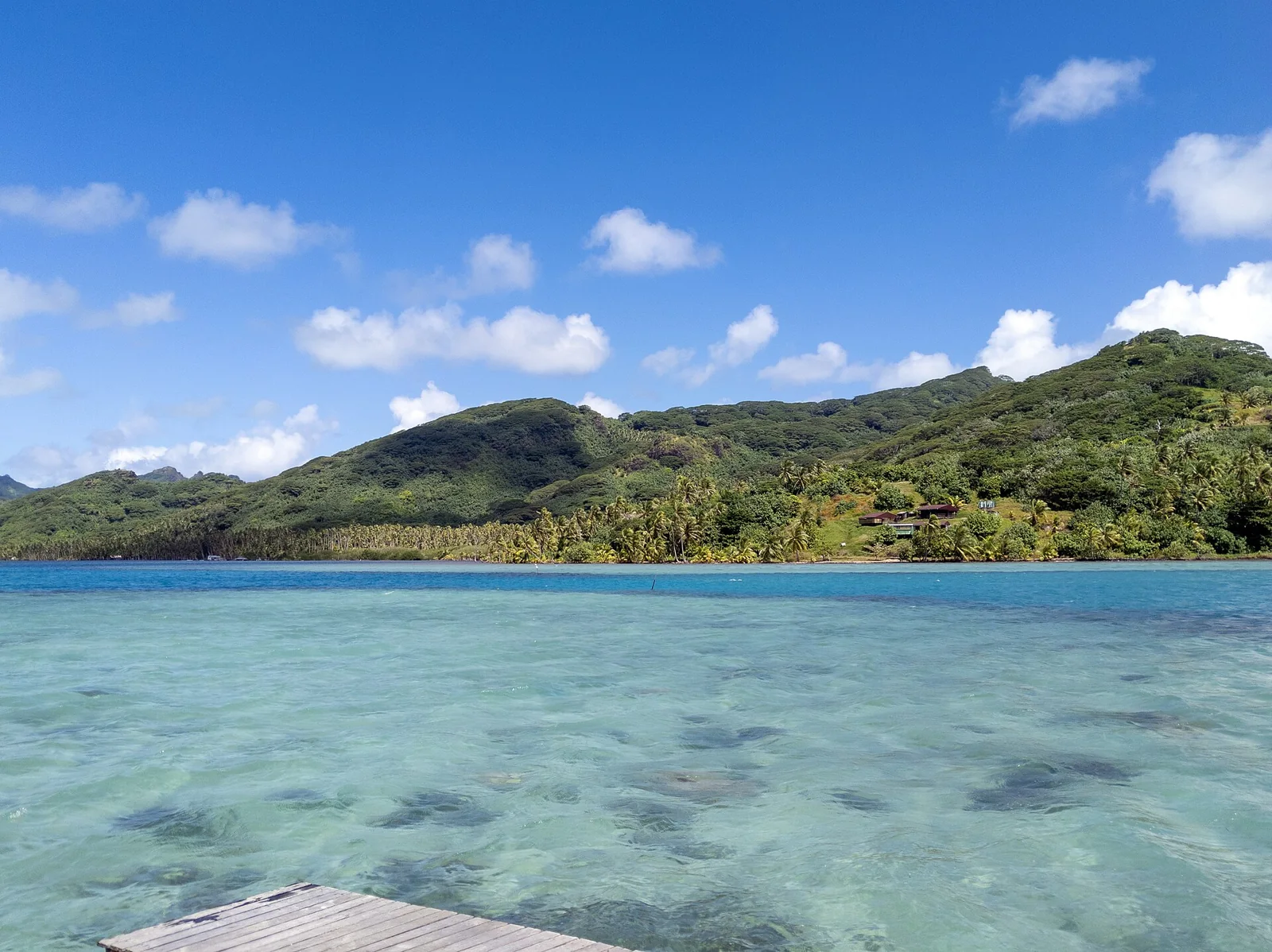 Les eaux claires du lagon et les collines de Huahine.