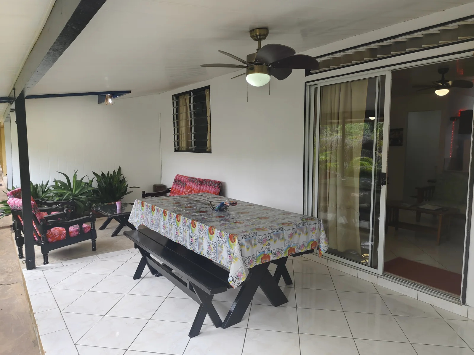 Terrasse couverte de l appartement avec table et banquette chez Fare Ara Location.