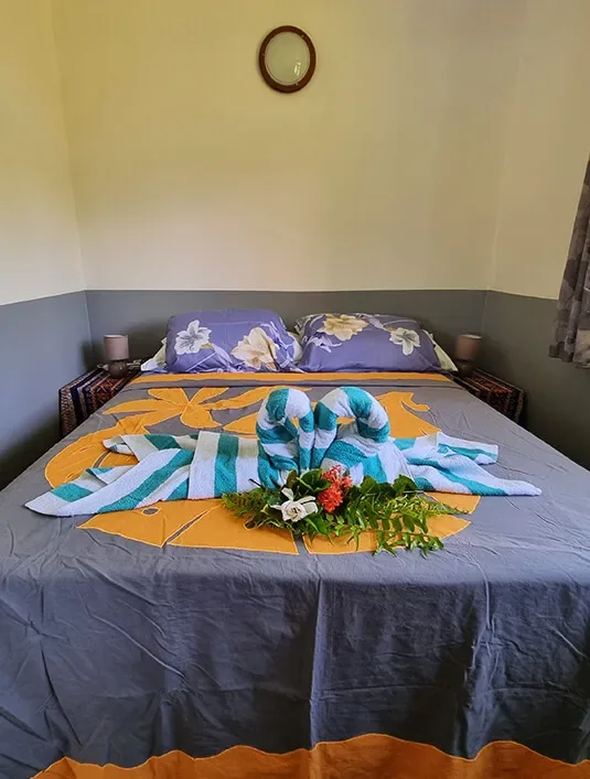 Chambre principale de Chez Here-Ata avec lit double et linge polynésien