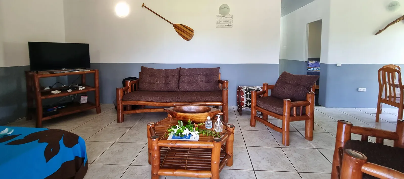 Salon de Chez Here-Ata avec sièges en bois et télévision