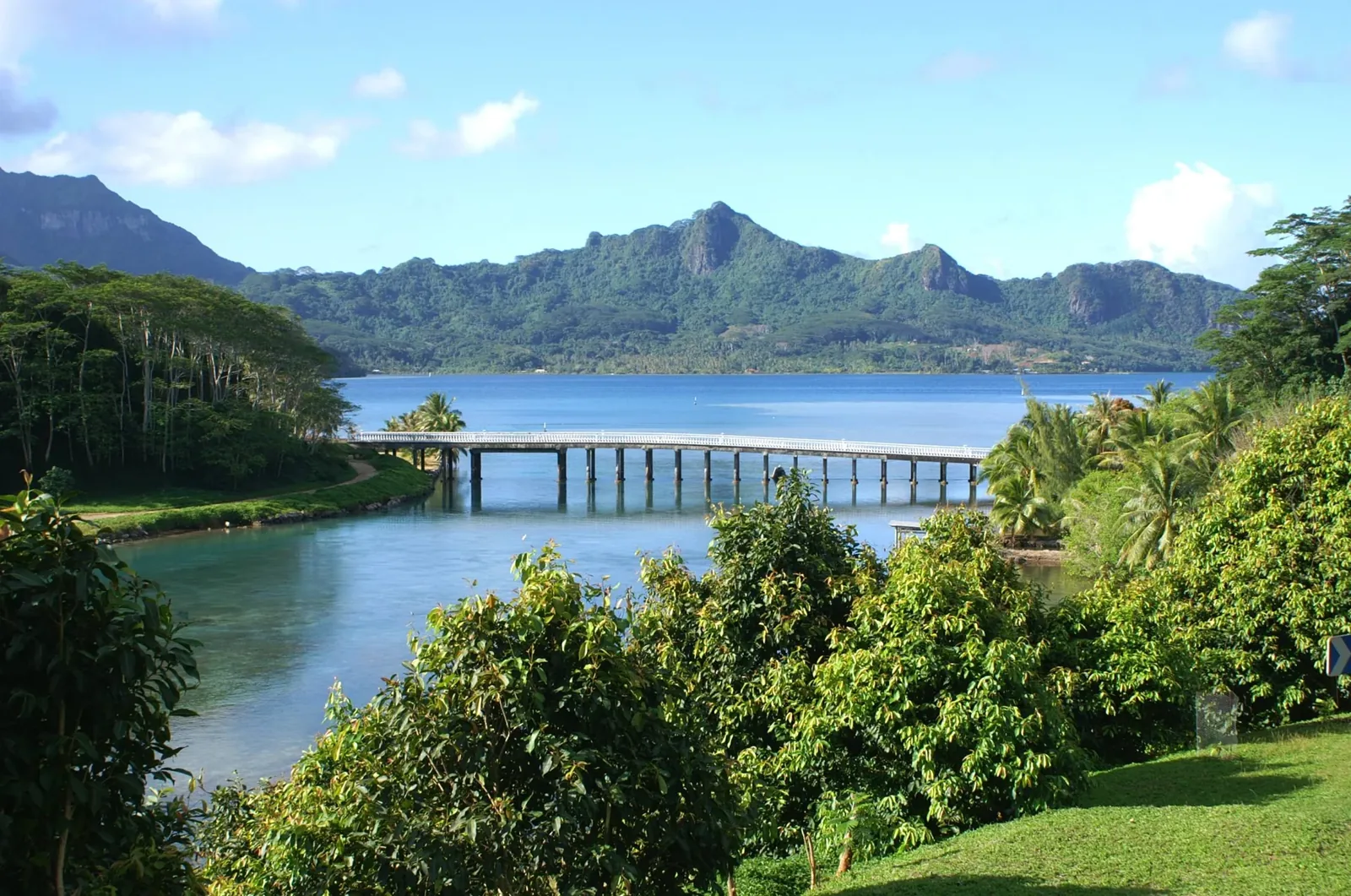 Le pont qui franchit le chenal entre Huahine Nui et Huahine Iti, devant des versants montagneux verdoyants.