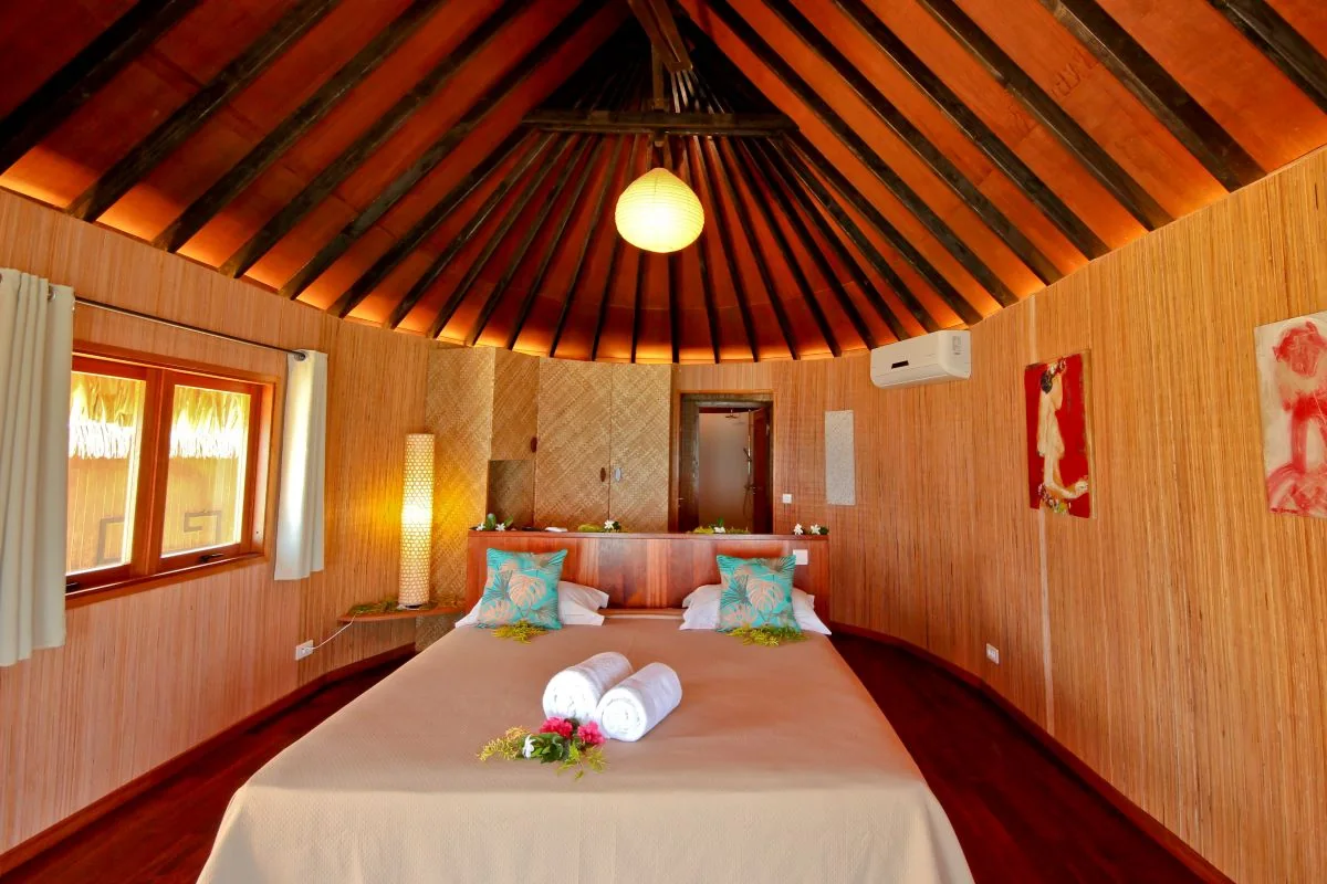 Chambre sous charpente en bois dans un fare traditionnel.