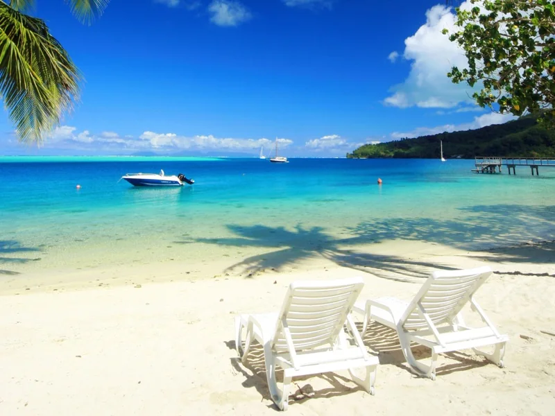 La plage et les transats devant le lagon.