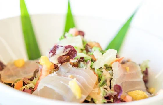 Une salade garnie de tranches de poisson et de fleurs au restaurant du Mahana.