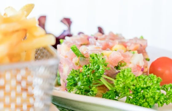 Un plat servi avec des frites et une salade verte au restaurant du Mahana.