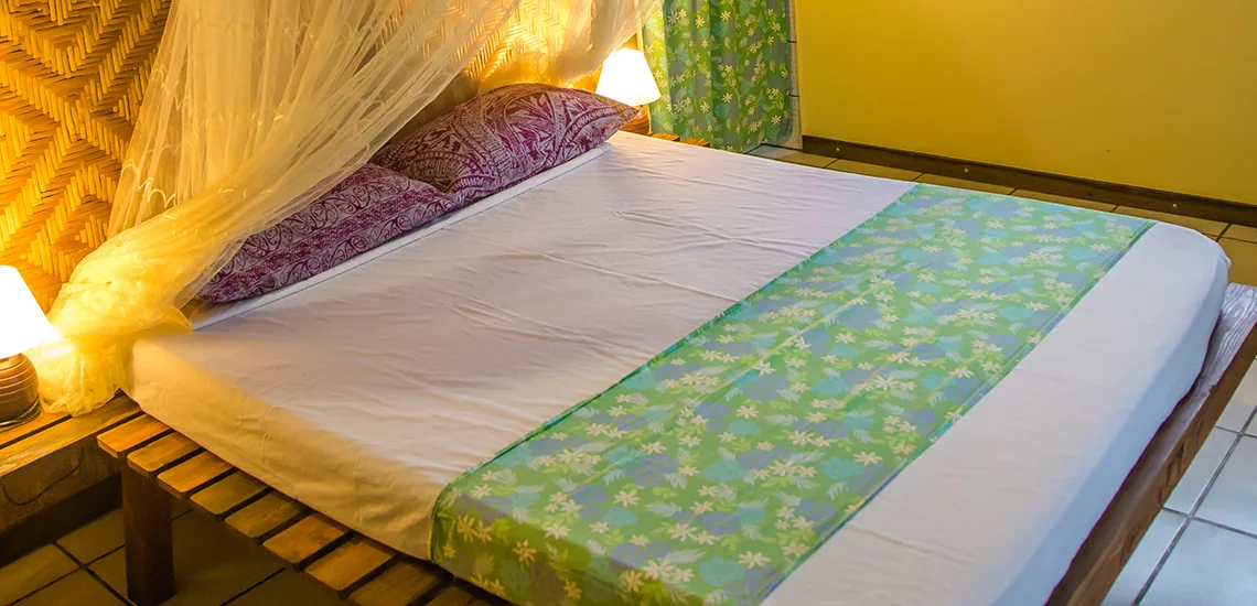 Lit double sous moustiquaire à la Pension Meherio i Huahine