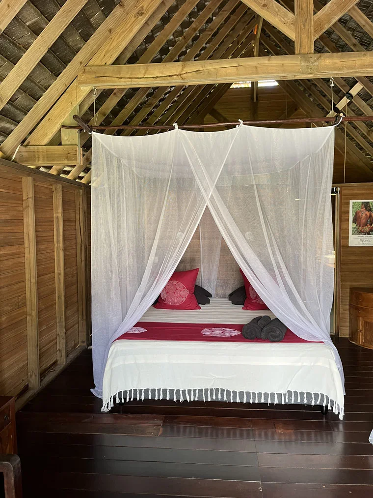 Lit double avec moustiquaire dans un bungalow du Moana Lodge