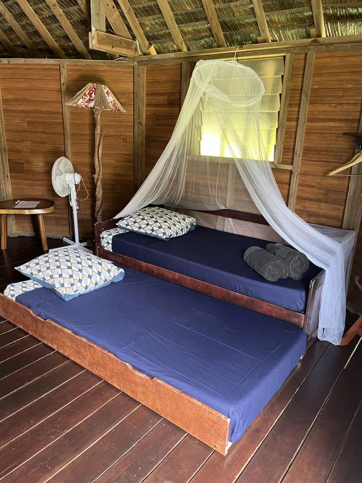 Lits simples avec moustiquaires dans un bungalow du Moana Lodge