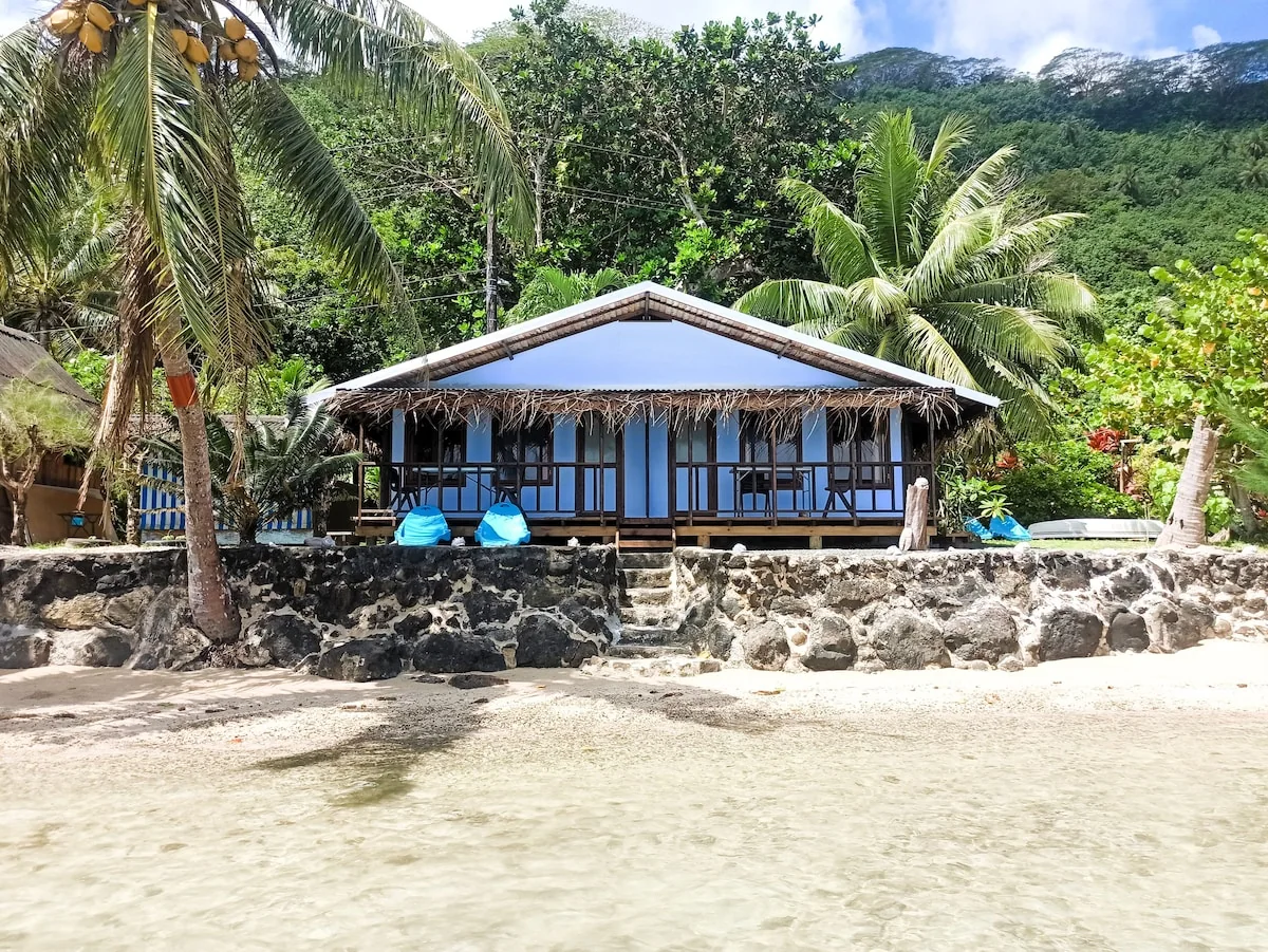 Bungalow bleu de Te Nahe Toetoe face a la plage, avec sa terrasse en bois.