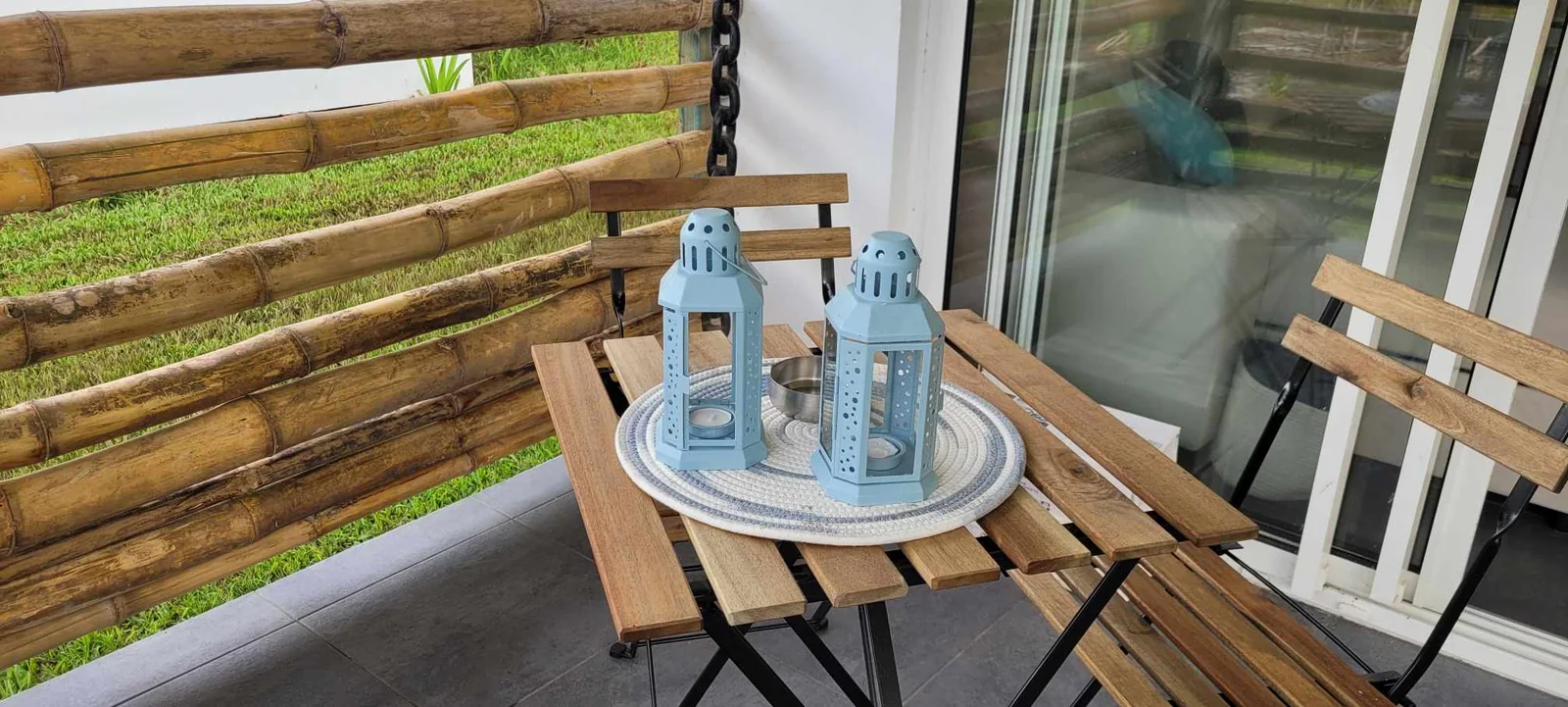 Terrasse en bois avec fauteuils et table à Te Ra'i Nui