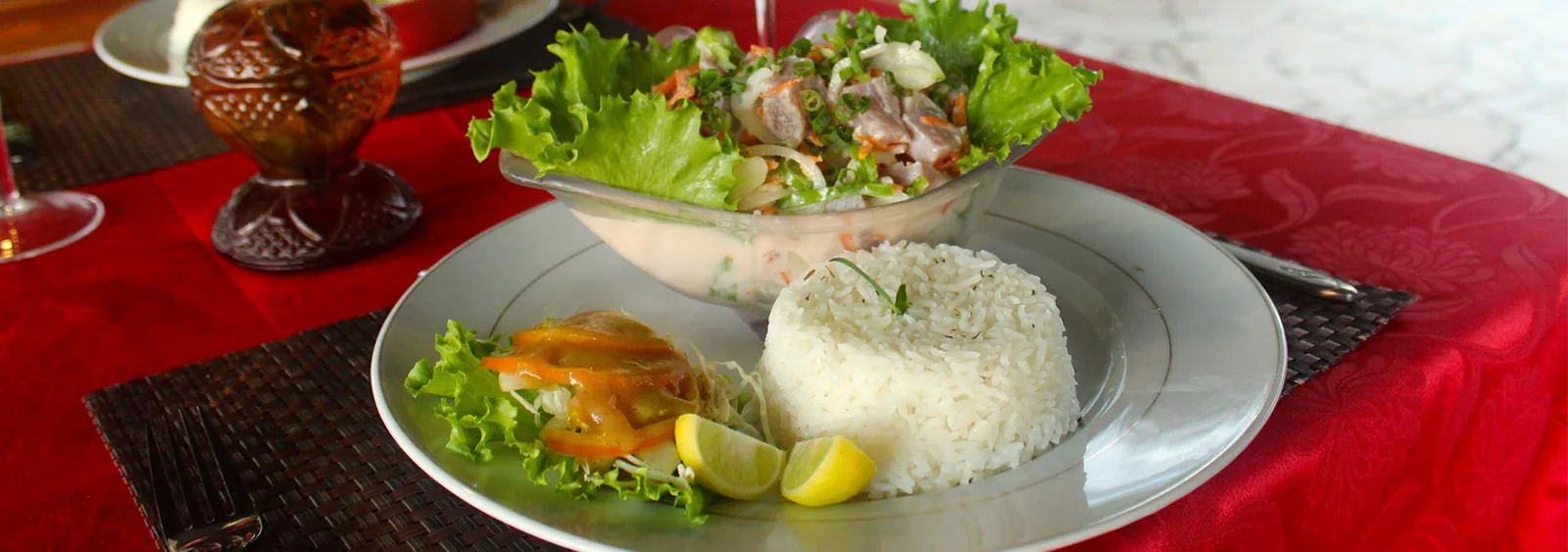 Un plat avec riz, salade et citron sur une table rouge du restaurant Tehina.