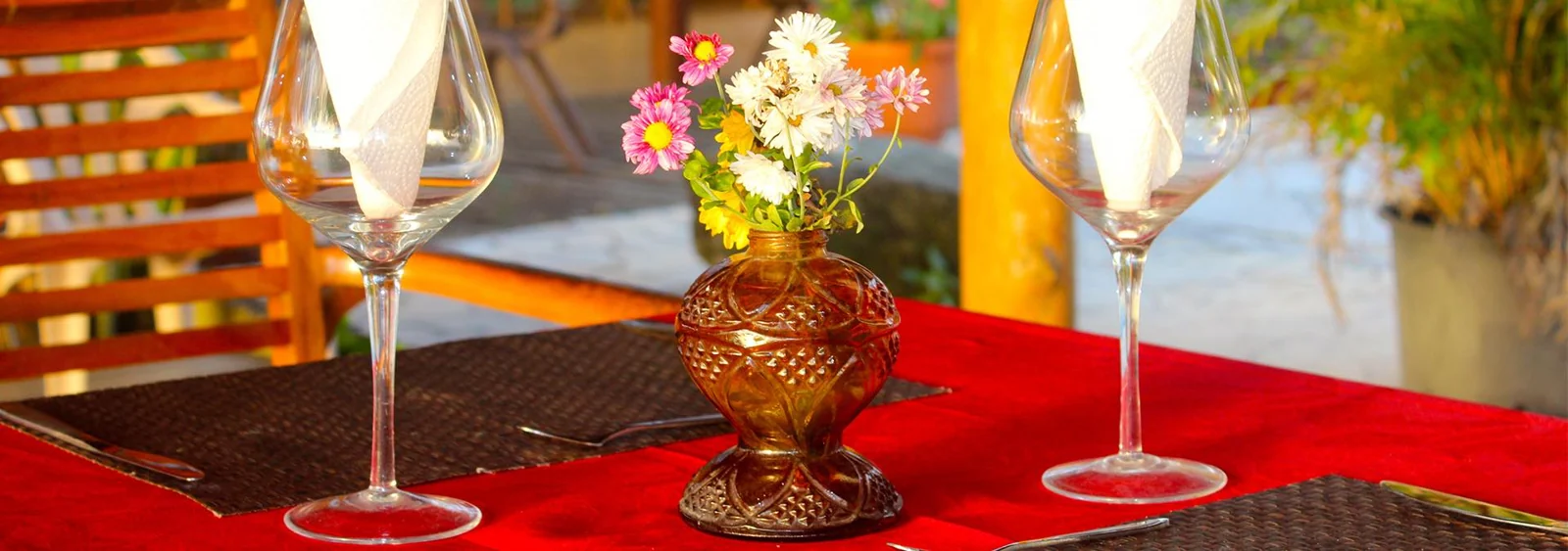 Deux verres, des serviettes pliées et un bouquet sur une table du restaurant Tehina.