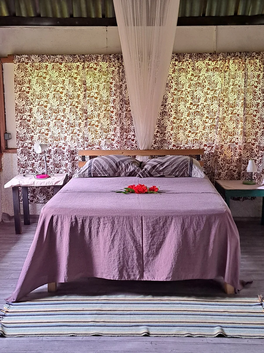 Chambre avec lit double et moustiquaire à Tifaifai & Café Huahine
